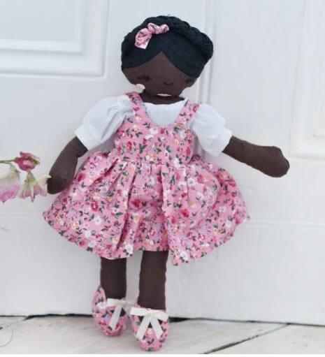 Black Craft Doll wearing a pink floral dress